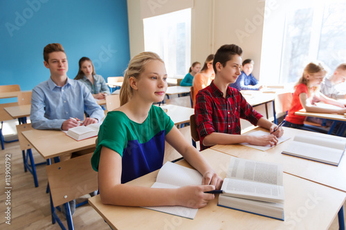 group of students with books at school lesson