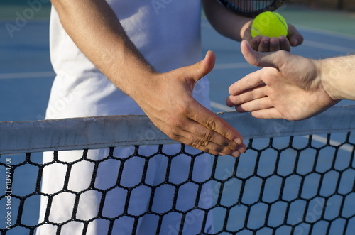 Tennis players shaking hands on the net, fair play, outdoors