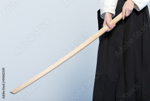 A girl's hands holding a wooden sword bokken
