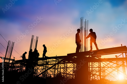 Silhouette engineer standing orders for construction crews to wo