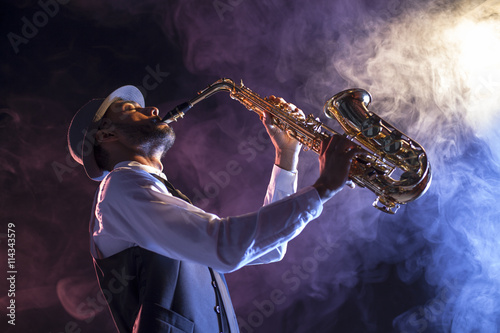 Saxofonista sobre escenario con humo