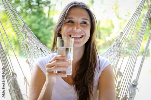 Młoda kobieta pije wodę ze szklanki 