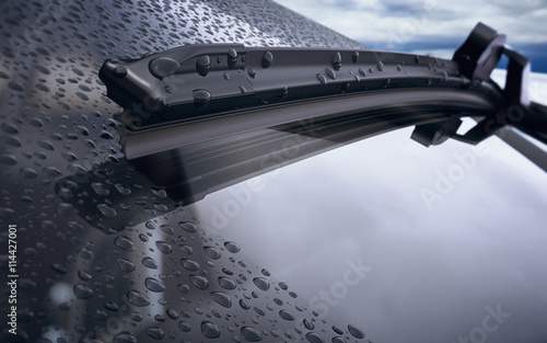 Car windshield with rain drops and frameless wiper blade closeup. 3d render