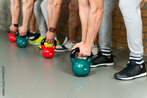 Skillful sportsmen training with weights