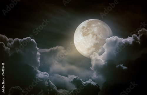 Nighttime sky with clouds, bright full moon.