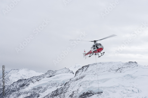small red helicoper on alpes mountains