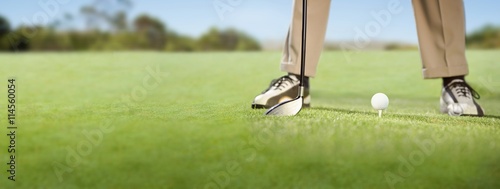 Golfer placing golf ball on tee