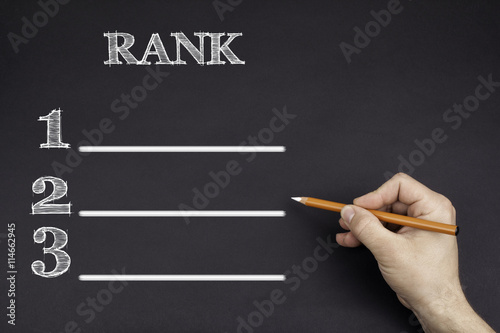 Hand with a white pencil writing: Rank blank list
