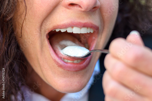 Woman taking a mouthful of cream or ice cream