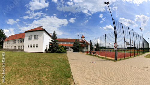 Boisko sportowe, budynek państwowej szkoły publicznej.