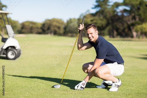 Side view of man placing golf ball on tee
