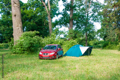A camp in the forest with a car