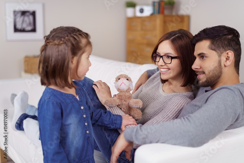 eltern reden mit ihrer tochter im wohnzimmer