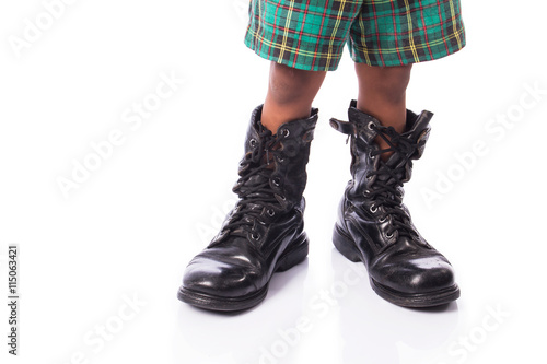 little boy wearing big shoe
