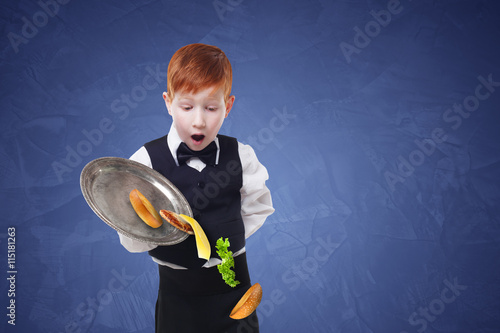 Clumsy little waiter drops food from tray while serving hamburger