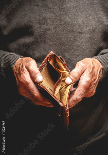 Empty wallet in the hands of an elderly man. Poverty in retirement concept