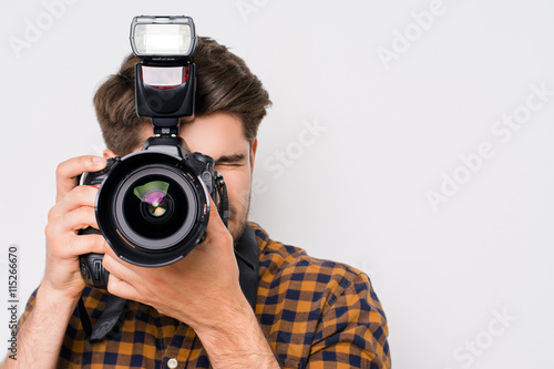 Young man focusing with digital camera isolated on white backgr