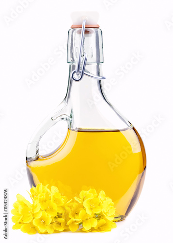 Extra virgin oil in a bottle with rapeseed flowers