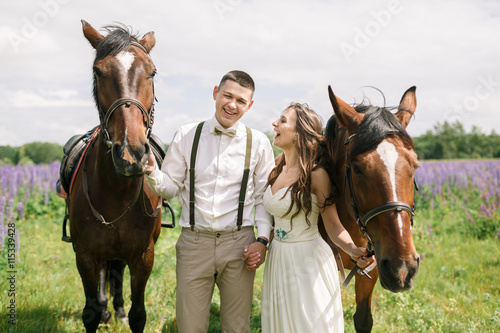 Happy wedding couple with horses