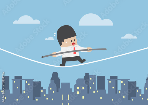 Businessman walking on a rope over the city