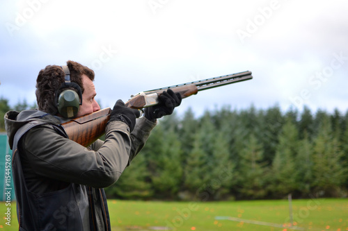 man shooting shotguns at clay pigeon outdoors