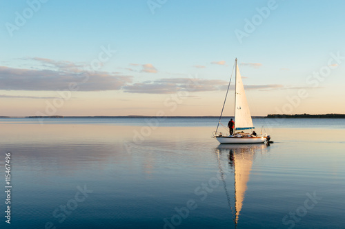 Sailing boat on a calm lake with reflection