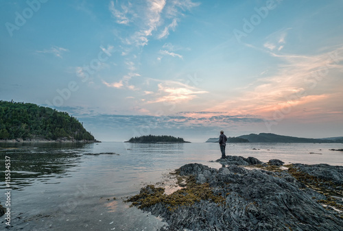 Man Standing on Rock Looking Out Over St. Lawrence River in Queb