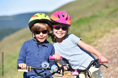 Portrait of cheerful kids riding bike