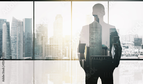 silhouette of business man over office background