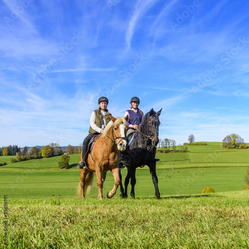 Zwei Reiterinnen auf ihren Pferden beim Ausritt