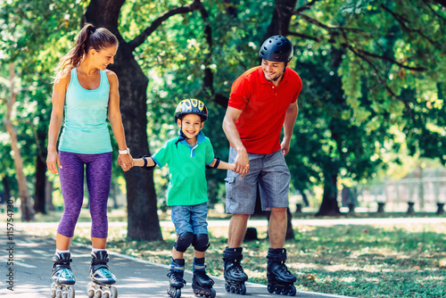 Family with one child roller skating in the park