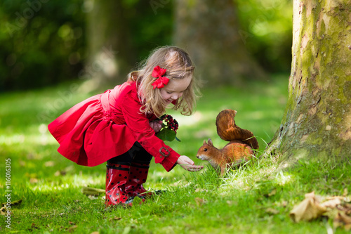 Little girl feeding squirrel
