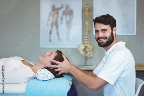 Physiotherapist giving head massage to a woman