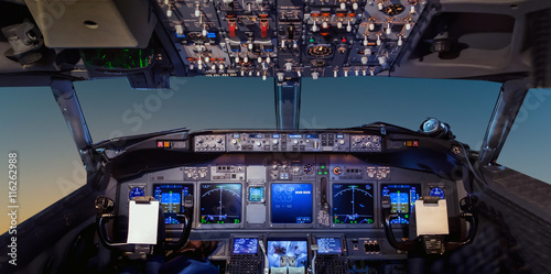 Interior of the cockpit Airplane flying above tropical sunset