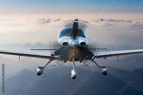 Privat plane or aircraft flight surrounded by mountains and rocks. Front view, close up