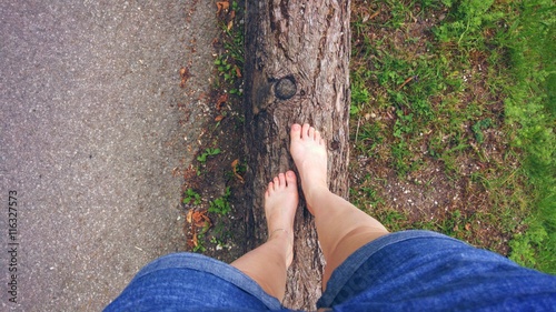 Barfuß in der Natur auf einem Baumstamm laufen