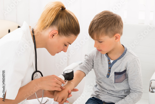 Doctor Examining Skin Of Little Boy