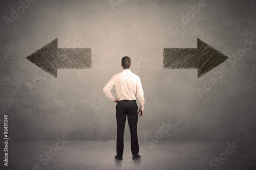 Business man taking a decision while standing in front of two gr