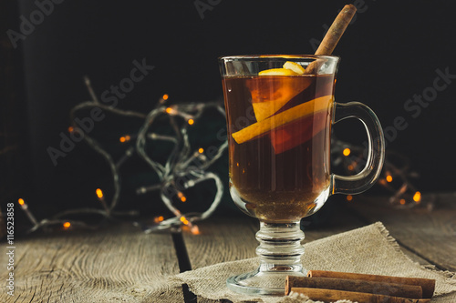 Mulled wine in glass and cinnamon pipes
