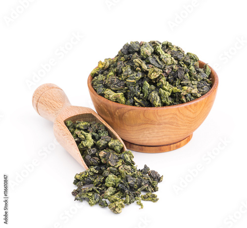 Tieguanyin oolong green tea in a wooden bowl isolated on white