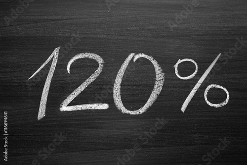 120 percent header written with a chalk on the blackboard