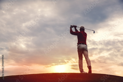 silhouette of man golfer with golf club at sunset. back view