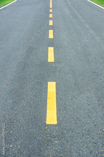 asphalt texture with yellow dashed line.