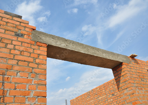 Close up on concrete lintel. Window or door concrete lintel on brick unfinished house construction.