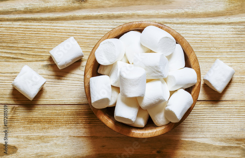 Large marshmallow in bowl, wooden background, top view