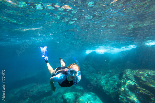 Female apnea swims in deep waters of the popular Similan Islands in Thailand, Andaman Sea.