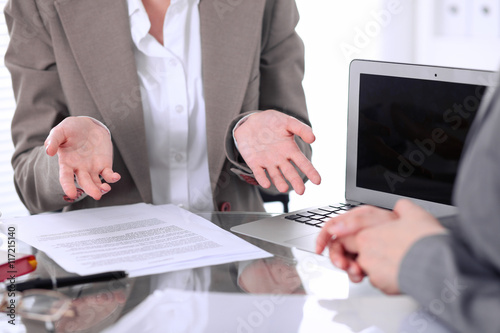 Group of business people or lawyers at meeting discussing contract papers. Woman showing that she do not understand how it happen or what to do