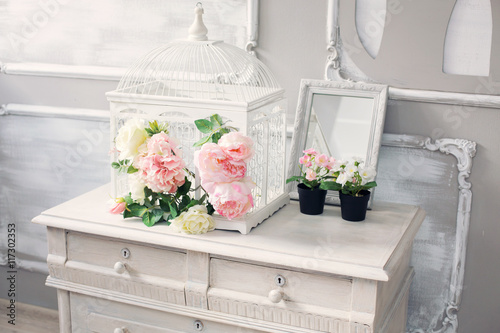 dresser with flowers in a light classical interior
