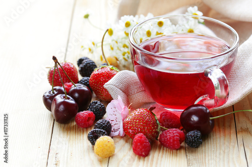 mix fruit tea in a glass cup and fresh berries