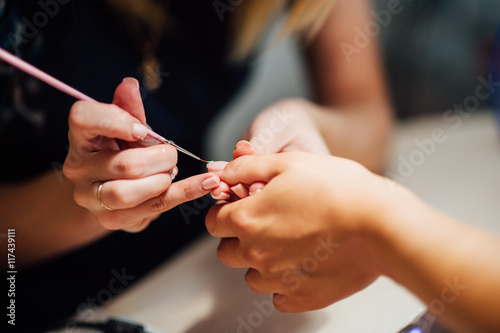 Woman in salon receiving manicure